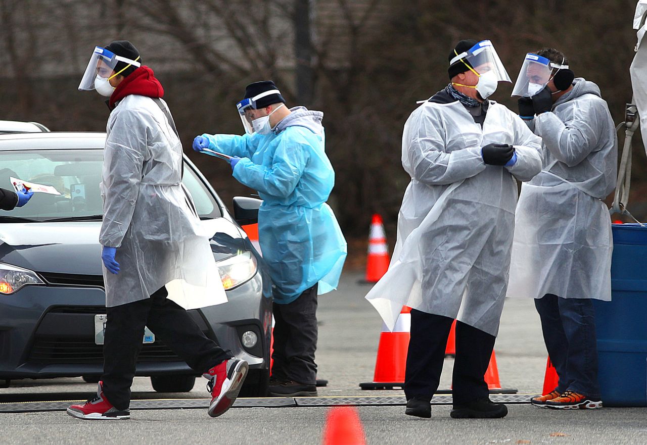 Health care workers on hand as they administer COVID-19 tests in the parking lot at McCoy Stadium in Pawtucket, Rhode Island on December 8. 