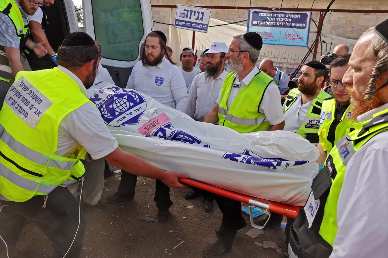 Israeli rescue teams carry a body bag into an ambulance in Meron, Israel, on April 30.