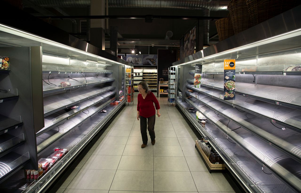 A woman looks at the few items left in the fresh meat and poultry fridges in a Johannesburg supermarket, Wednesday, March 18, amid panic-buying due to the coronavirus outbreak. 