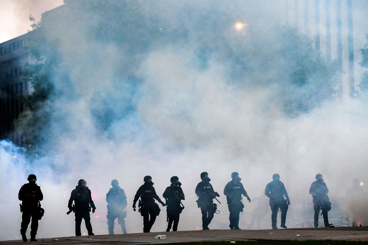 Police officers walk through a cloud of tear gas as they try to disperse protesters on May 30 in Denver, Colorado. 