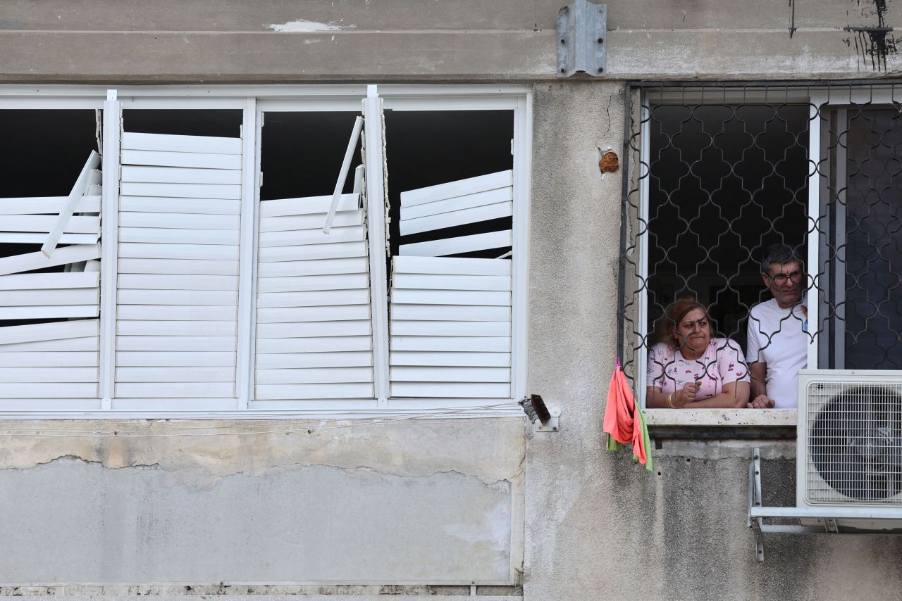 Residents look out from the window of their building in the southern city of Ashkelon, Israel, on October 9, 2023.