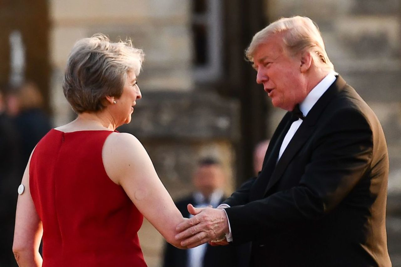 Britain's Prime Minister Theresa May (L) shakes hands with US President Donald Trump (R) as she welcomes Trump and his wife US First Lady Melania Trump for a black-tie dinner with business leaders at Blenheim Palace on July 12, 2018. 