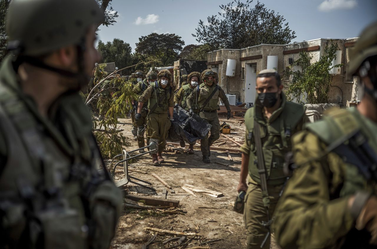 Israeli forces extract dead bodies of Israeli residents from a destroyed house in Kfar Aza, Israel, on October 10.