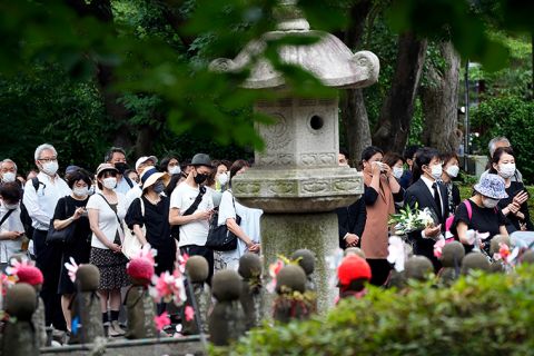 People line up to offer flowers and prayers for former Prime Minister Shinzo Abe, at Zojoji Temple prior to his funeral Tuesday, July 12, in Tokyo. 