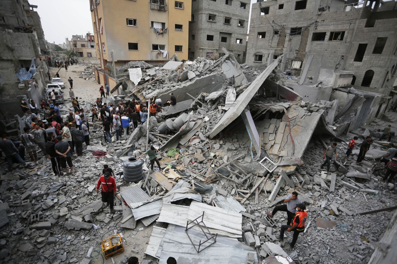 Civil defense teams and local residents carry out search and rescue work in the rubble of a house that was destroyed by an Israeli attack on the Nuseirat refugee camp in Gaza on May 10. 