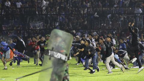 Soccer fans enter the pitch during a clash between supporters at Kanjuruhan Stadium in Malang, East Java, Indonesia on Oct. 1.