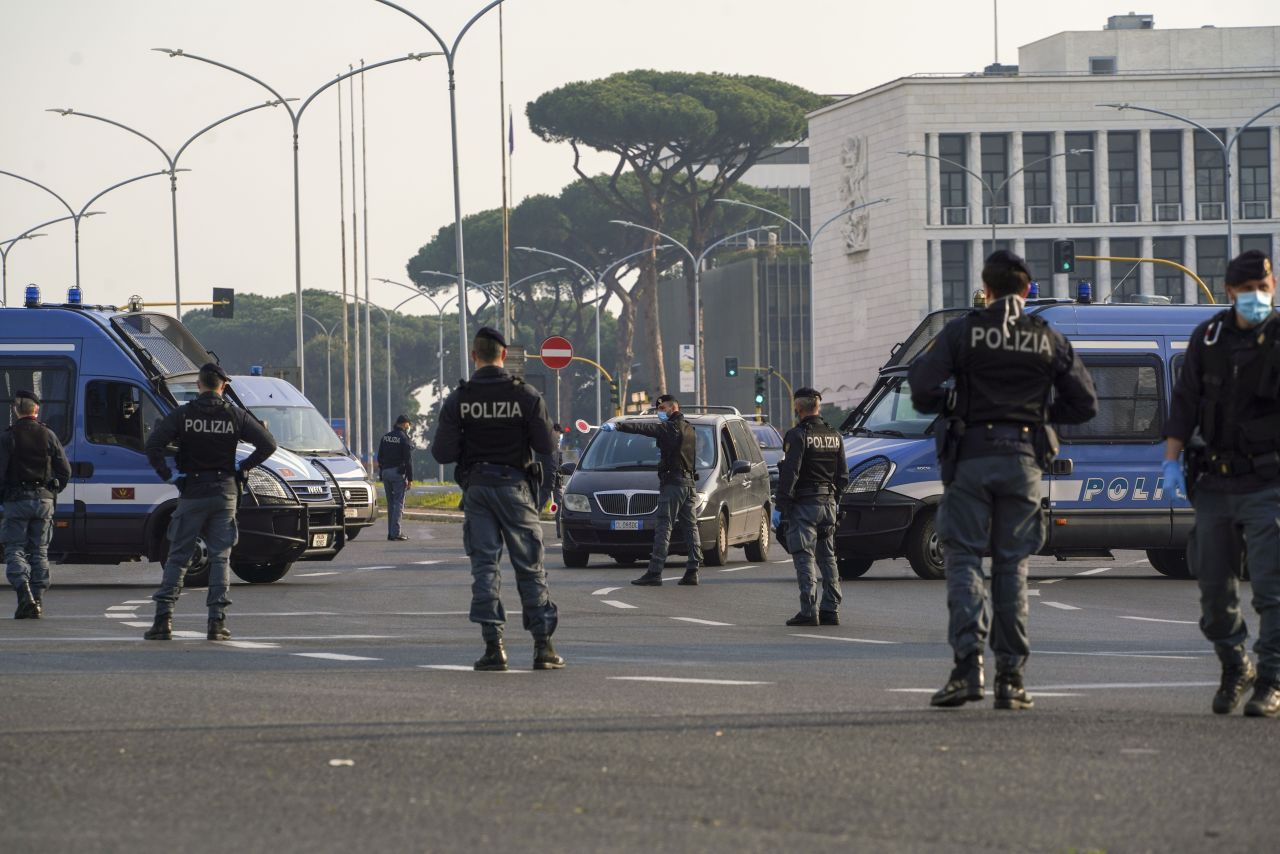 Police officers signal drivers to pull over at a road block in Rome on April 13.