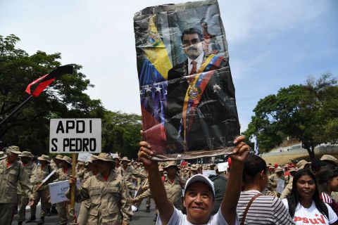 A supporter displays a poster of Venezuelan President Nicolas Maduro during a rally on May Day in Caracas.