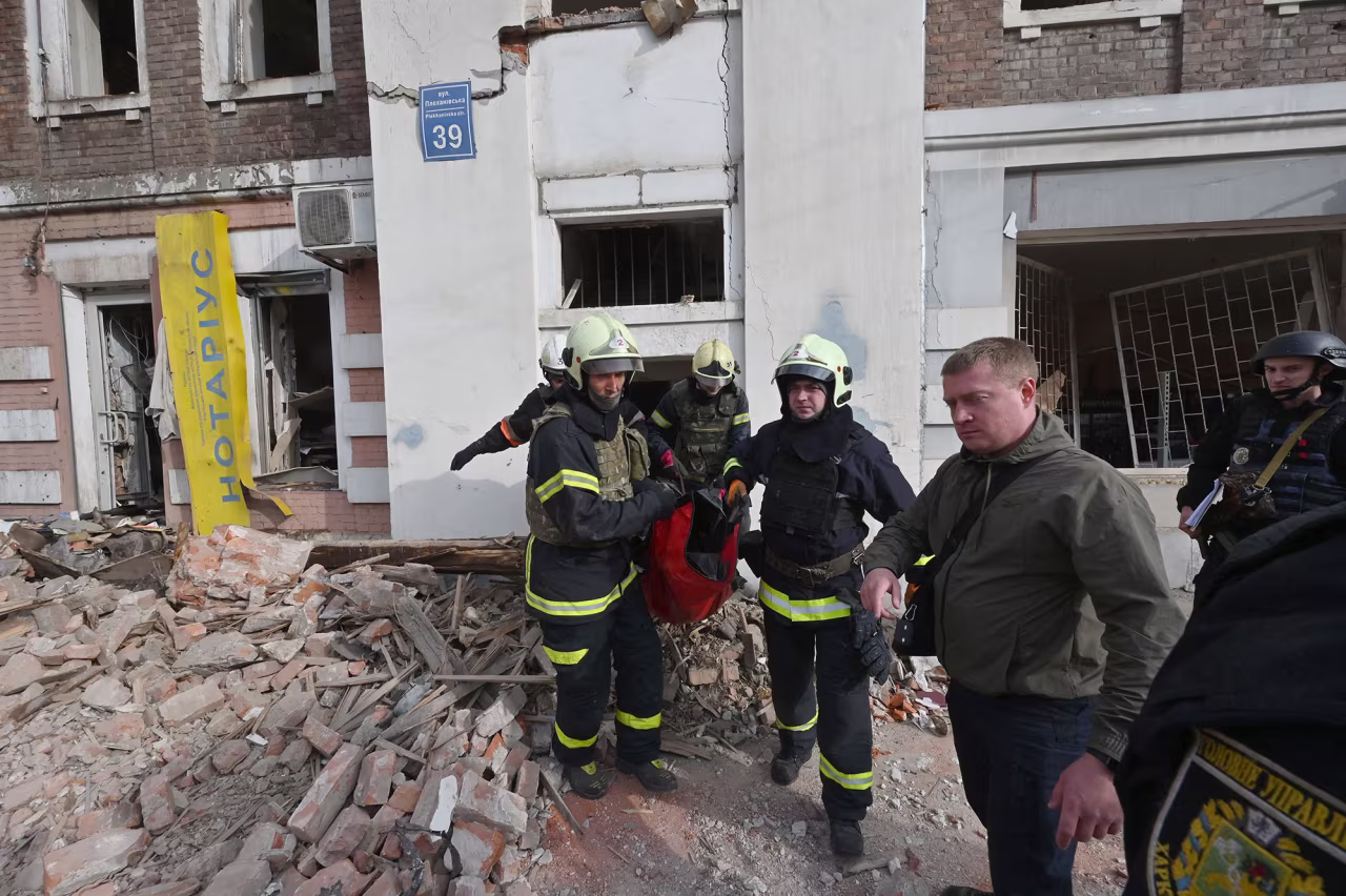Rescuers evacuate the body of a deceased woman from a destroyed residential building following a Russian missile strike in Kharkiv, Ukraine, on October 6.