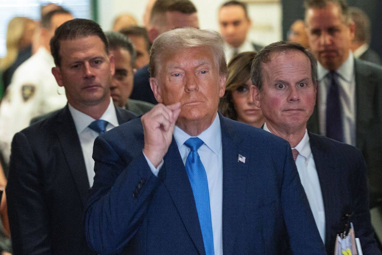 Former President Donald Trump motions a zipped lip as he walks out of the courtroom during a break in proceedings at New York Supreme Court on Monday.