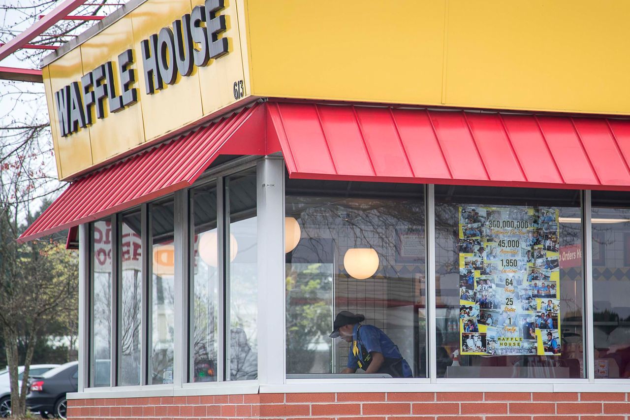 A Waffle House employee can be seen cleaning tables at this Lithia Springs location, Thursday, March, 19.