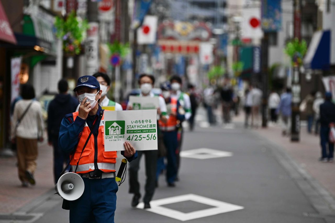 Municipal employees patrol a street asking people to stay home amid the coronavirus outbreak in Tokyo on May 4.