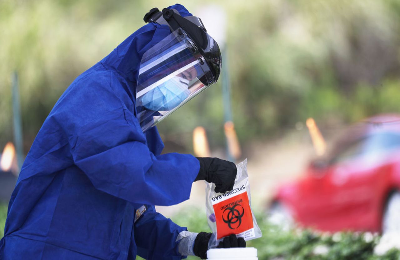 Volunteer Jennifer Niebergall holds a specimen bag during drive-through coronavirus testing at Malibu City Hall on April 8 in Malibu, California. 