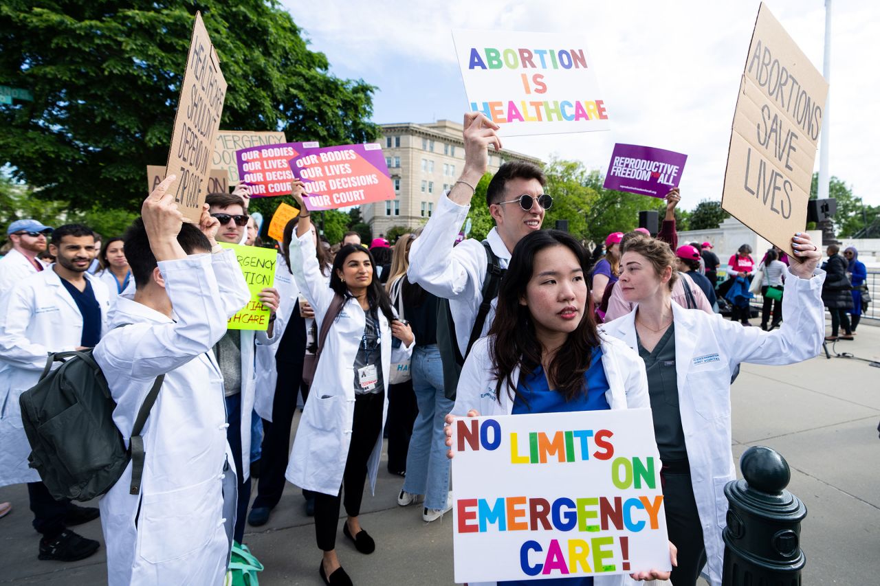 Healthcare workers hold signs outside of the Supreme Court before the court's oral arguments in Idaho v. United States in Washington, DC, on April 24.