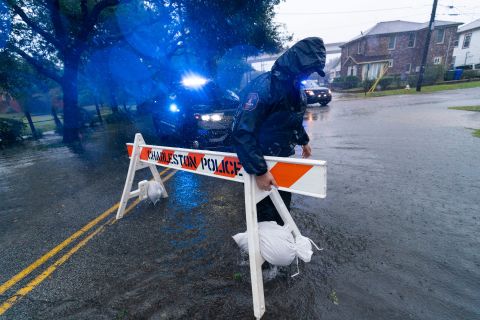 A police officer moves a barricade to block a flooded street in Charleston, South Carolina, on Friday.