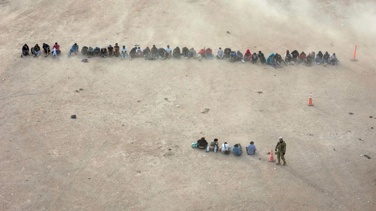 A Texas National Guard soldier watches over immigrants who had crossed the US-Mexico border on March 13 in El Paso, Texas.