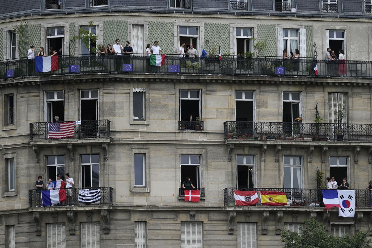 People stand on balconies in Paris to watch the ceremony. 