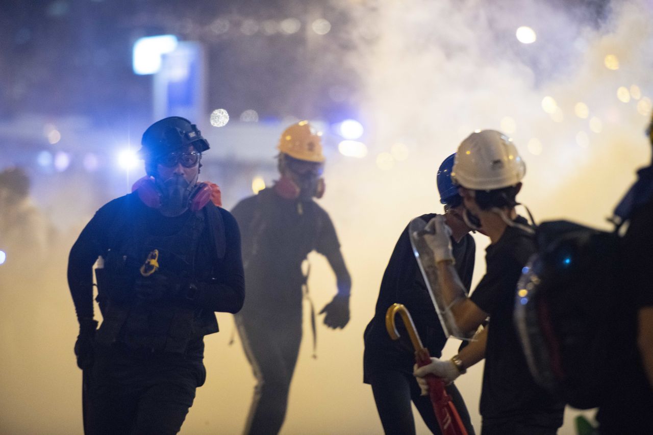 Protesters run from riot police on Sunday night.