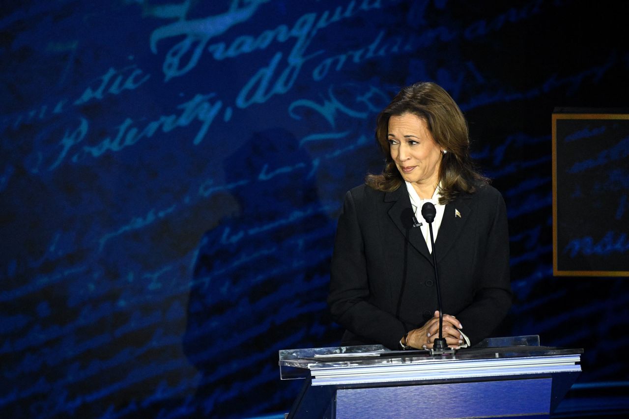 Harris listens as former President Donald Trump speaks.