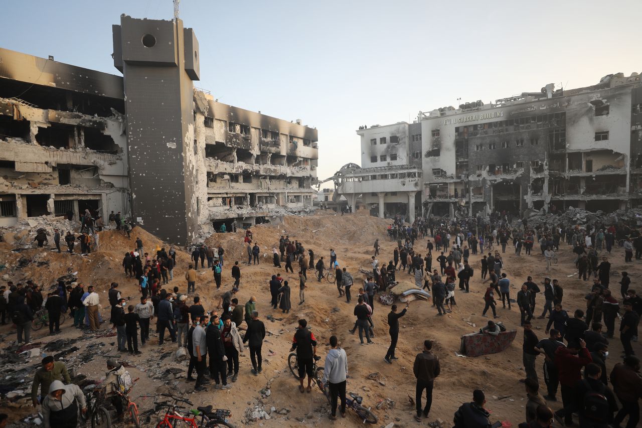 Palestinians gather around the destroyed Al-Shifa hospital.
