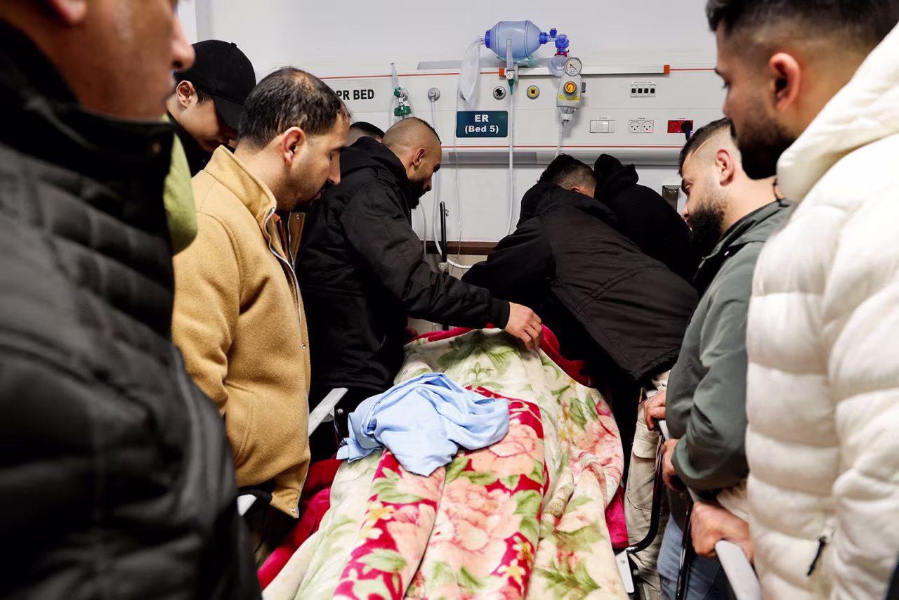 Mourners react next to the body of a Palestinian killed in the raid January 30.