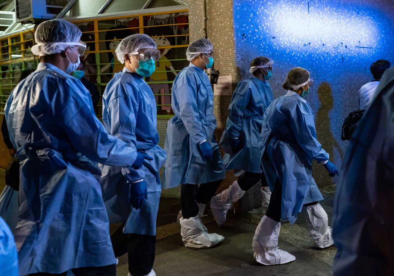 Police arrive at a public housing building as residents are evacuated from their home to a quarantine center after multiple infections of the novel coronavirus at Fu Heng Estate on March 14 in Hong Kong.