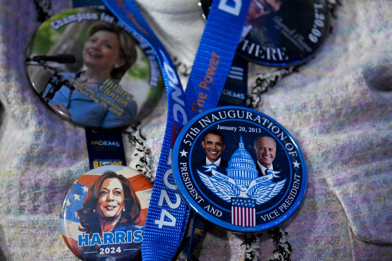 A Democratic National Convention attendee wears buttons from past Democratic presidential tickets alongside a Harris 2024 button. 