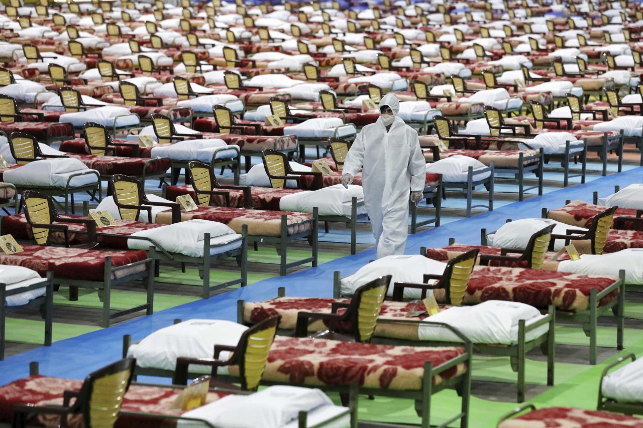 A person in protective clothing walks through a temporary hospital for coronavirus patients in Tehran, Iran, on March 26.