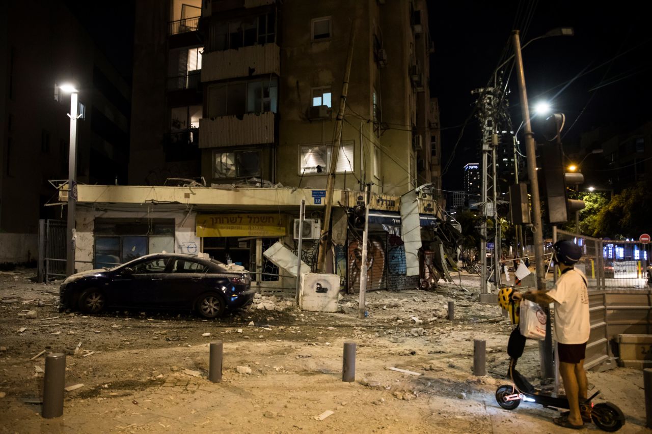 A man passes the scene where a rocket fired from Gaza hit a building on October 7, 2023, in Tel Aviv, Israel.