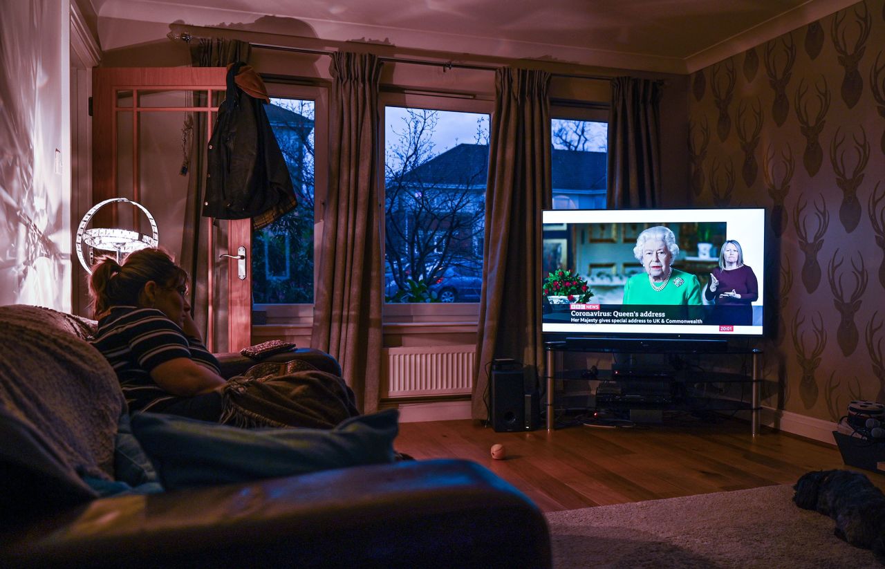 A woman watches Queen Elizabeth II's televised address to the nation on April 5, in Glasgow, Scotland.