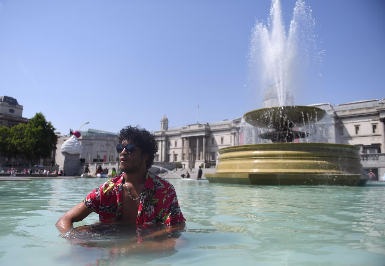 A man cools himself in a fountain at Trafalgar Square in London, England, on Tuesday, July 19.