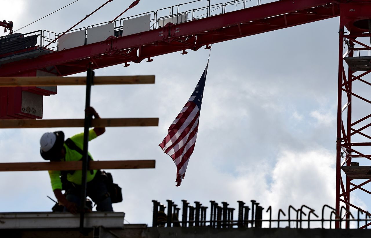 An American flag flies from a crane as a construction worker helps build an apartment complex on January 25 in Los Angeles, California.