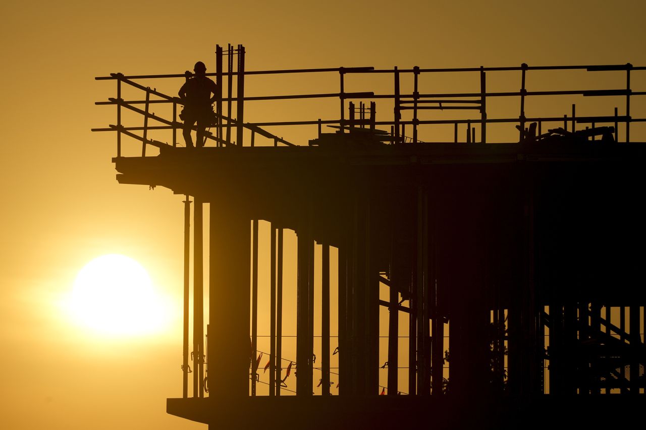 Construction workers start their day as the sun rises on a building in Carmel, Indiana, on August 27.