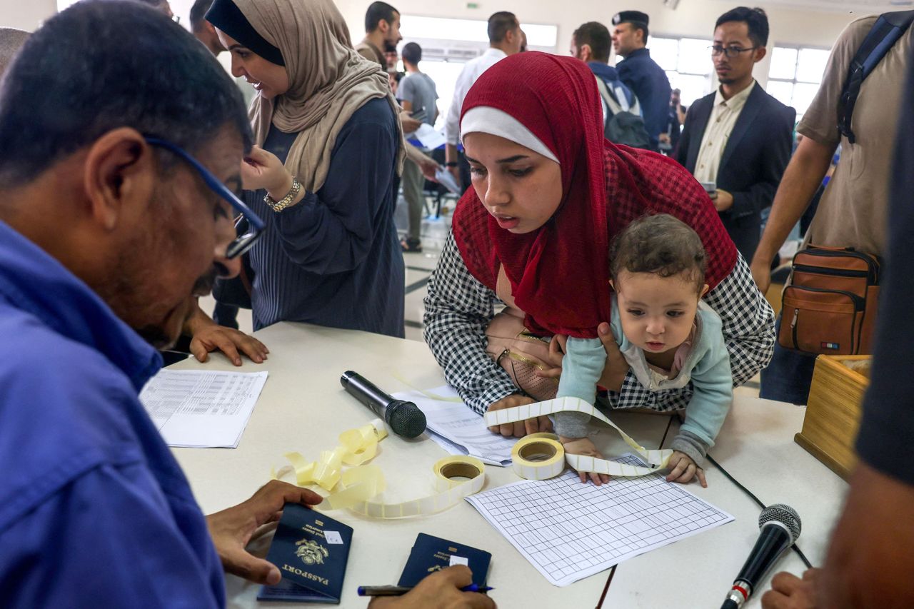 Civilians display their documents as they prepare to cross the Rafah border point between Gaza and Egypt on November 2.