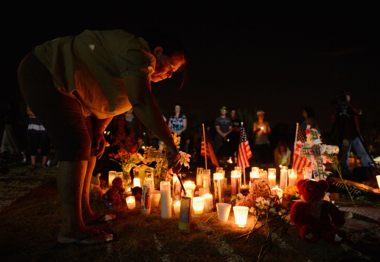 A woman lights candles at a makeshift memorial during a vigil for victims of the Century 16 movie theatre where a gunmen attacked movie goers during an early morning screening of the new Batman movie "The Dark Knight Rises"?on July 20, 2012, in Aurora, Colorado. 