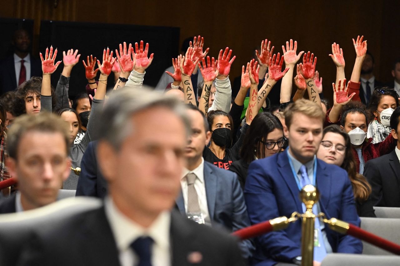 Protesters raise their painted hands as US Secretary of State Antony Blinken and Defense Secretary Lloyd Austin testify during a Senate Appropriations Committee hearing to examine the national security supplemental request, on Capitol Hill in Washington, DC, on October 31. 