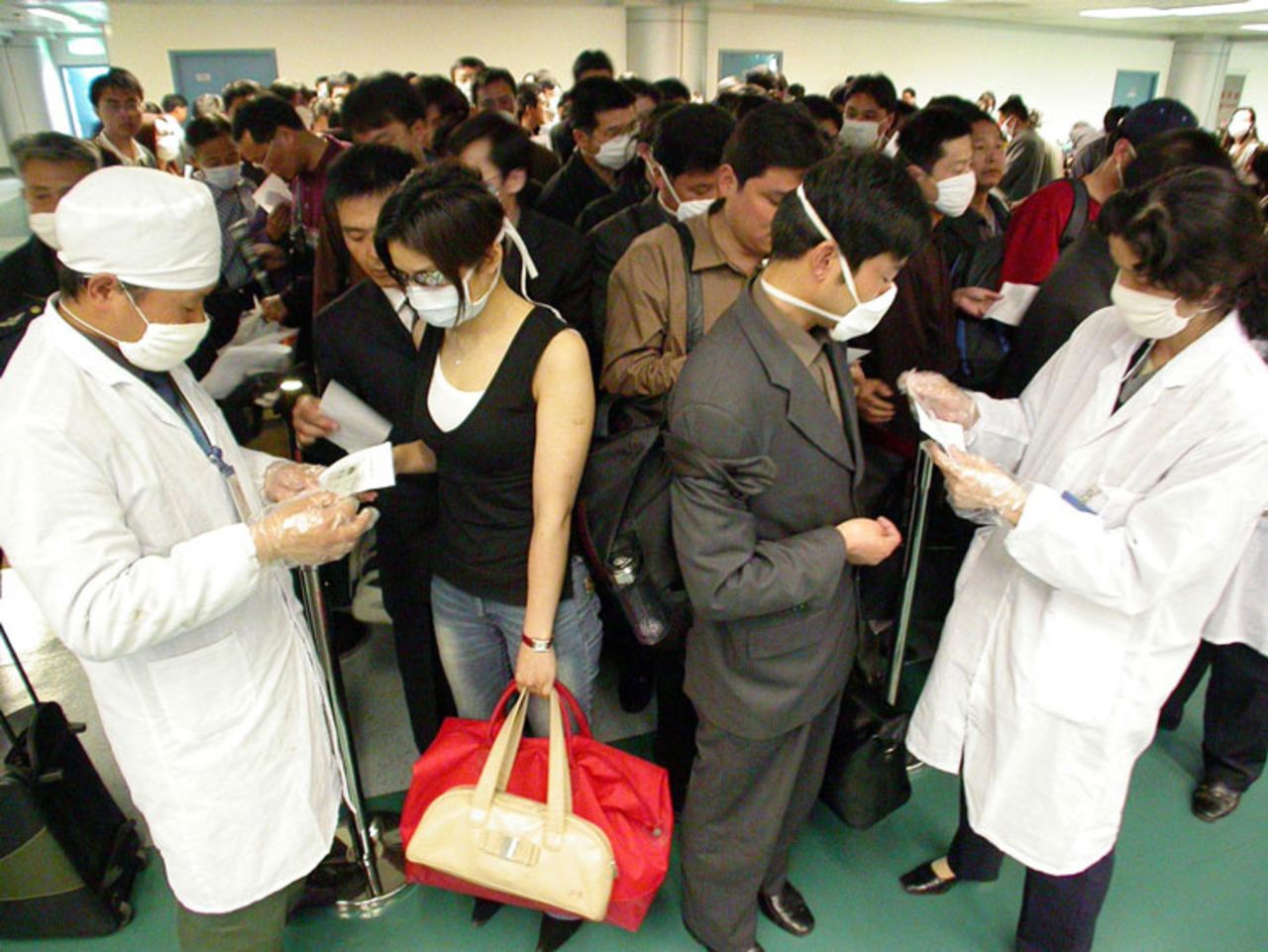 Chinese health officials check the health declarations by passengers boarding flights at the Nanjing airport on April 25, 2003.