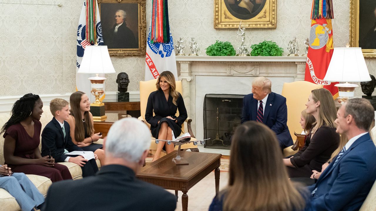 President Donald Trump smiles while chatting with Barrett's children.