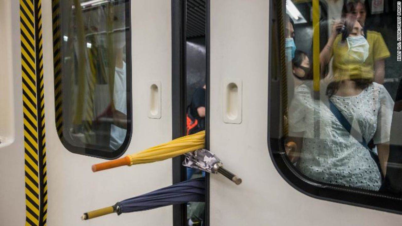 A group of protesters prevent the doors of a commuter train from closing on August 5.