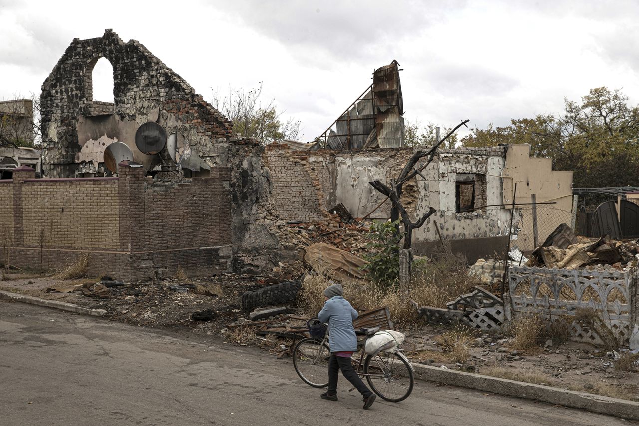 A woman walks past damaged buildings in the Kherson region on October 24.