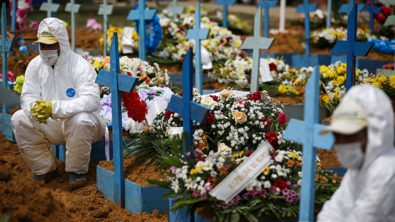 Cemetery workers sit on graves in January during a funeral at the Nossa Senhora Aparecida Cemetery in Manaus, Brazil.
