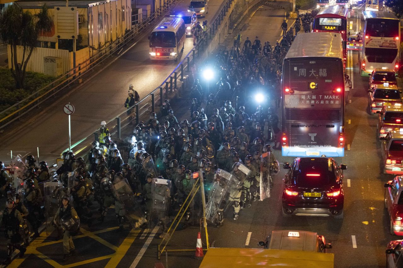 Riot police follow protesters into Causeway Bay from Gloucester Road Sunday night.