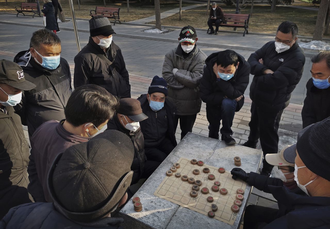 Men wear masks as they play Chinese chess in a Beijing park on January 31, 2020.