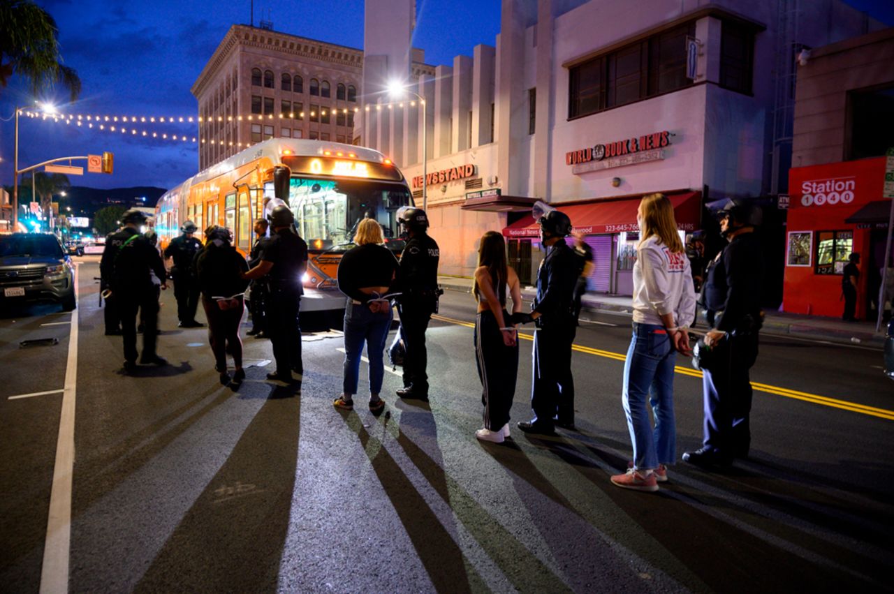 People are loaded onto buses by police officers after being arrested in Hollywood, California, on June 1, as a third night of curfews followed days of massive protests against George Floyd's death in Minneapolis. 