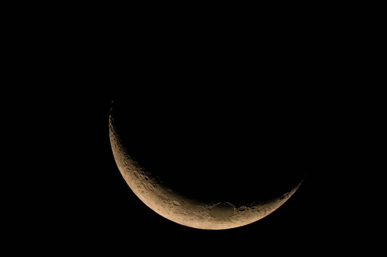 The crescent moon appears in Colombo, Sri Lanka, on March 13.