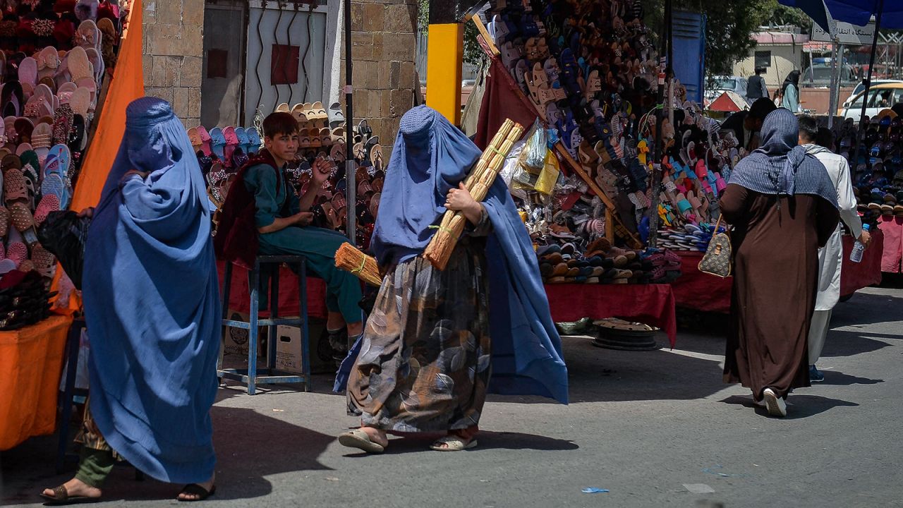 Burqa clad Afghan women shop at a market area in Kabul on August 23.