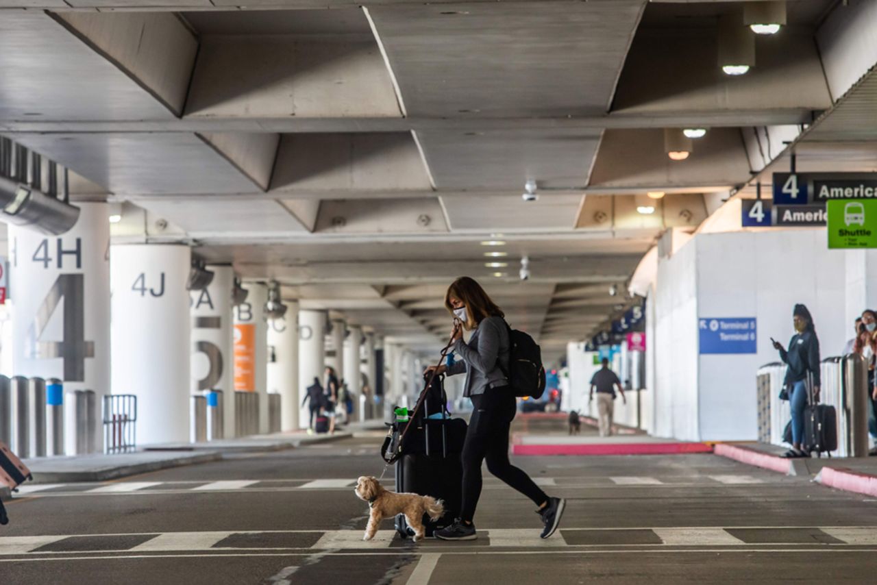 A woman crosses the street at LAX airport on May 22, in Los Angeles.