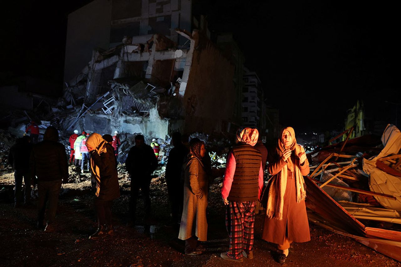 People gather near a collapsed building in Iskenderun, Turkey, on Monday, February 6, 2023.