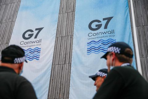 Police officers stand near a sign outside the media center on the first day of the G7 summit in Carbis Bay, England, on Friday, June 11. 