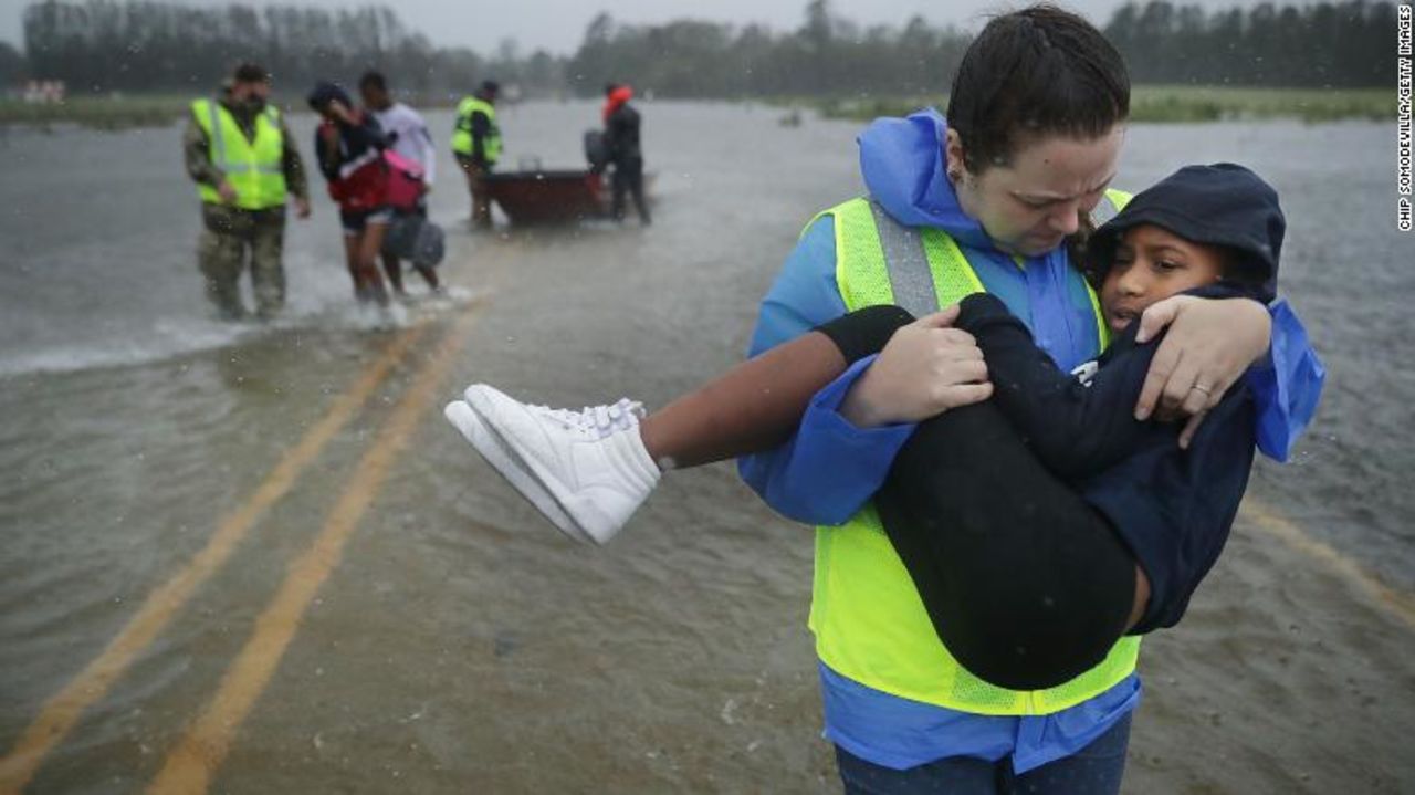 Volunteers from the Civilian Crisis Response Team help rescue three children from their flooded home in James City, North Carolina.